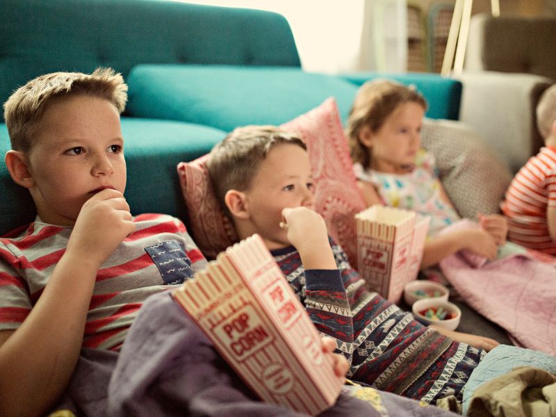 Barn tittar på film  & äter popcorn